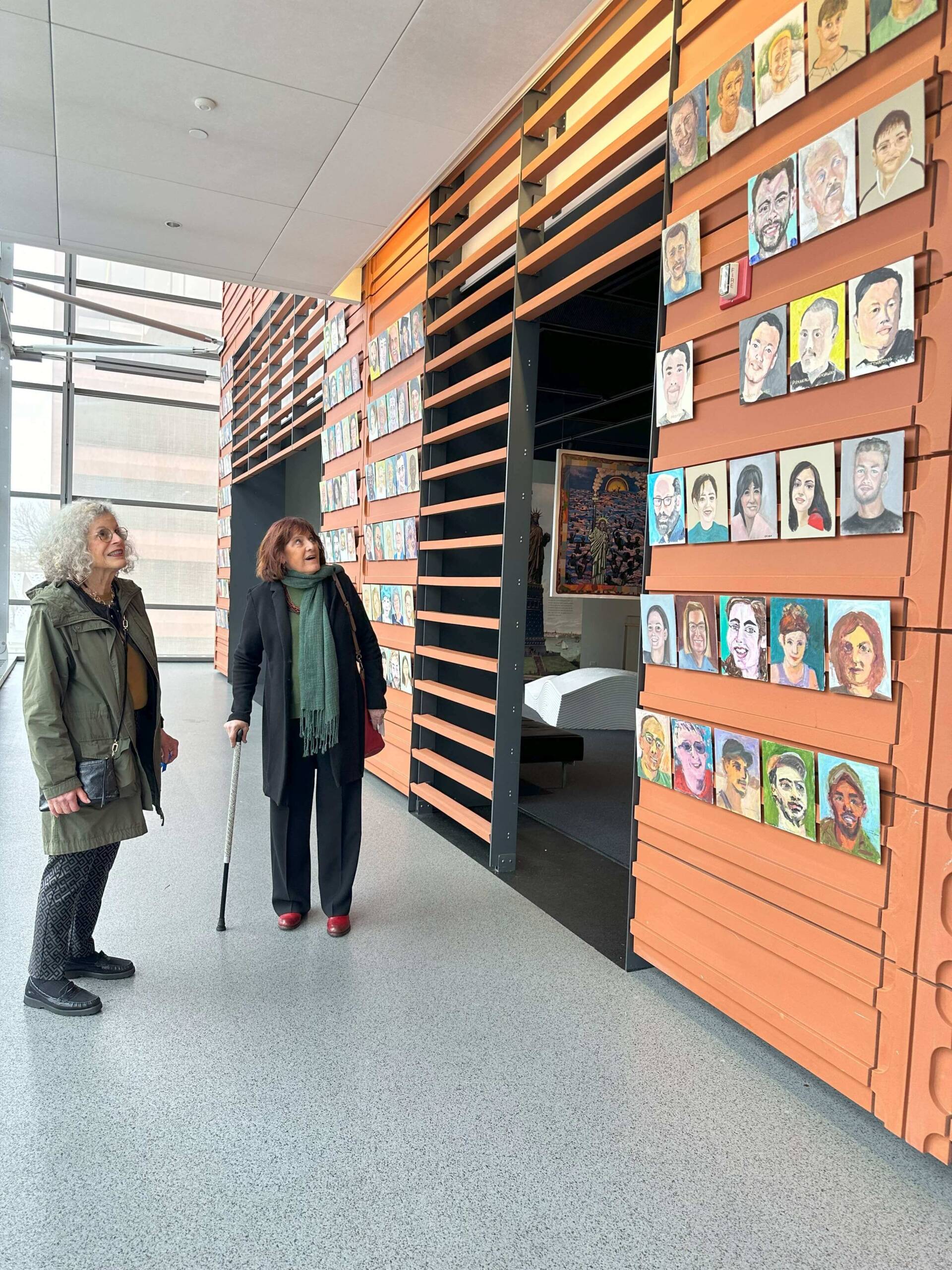 Their Portraits, artists Nancy Gordon and Sivia Katz Braunstein view the installation
